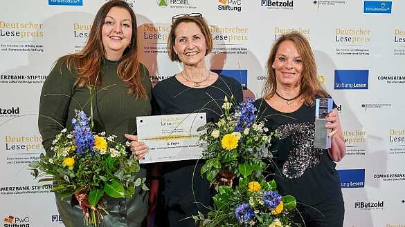 Mareike Prigge, Susanne Killing und Gaby Kölling nehmen, stellvertretend für das Kinder- und Familienzentrum Haus Windeck, den 3. Preis für Herausragende Sprach- und Leseförderung in Kitas entgegen