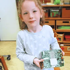 Kind hält stolz eine Platine in der Hand