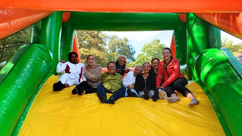 Team des Kinder- und Familienzentrums Graubündener Straße auf der Rutsche der Hüpfburg