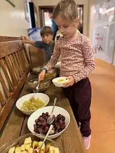 Kinder befüllen sich ihre Müslischüsseln