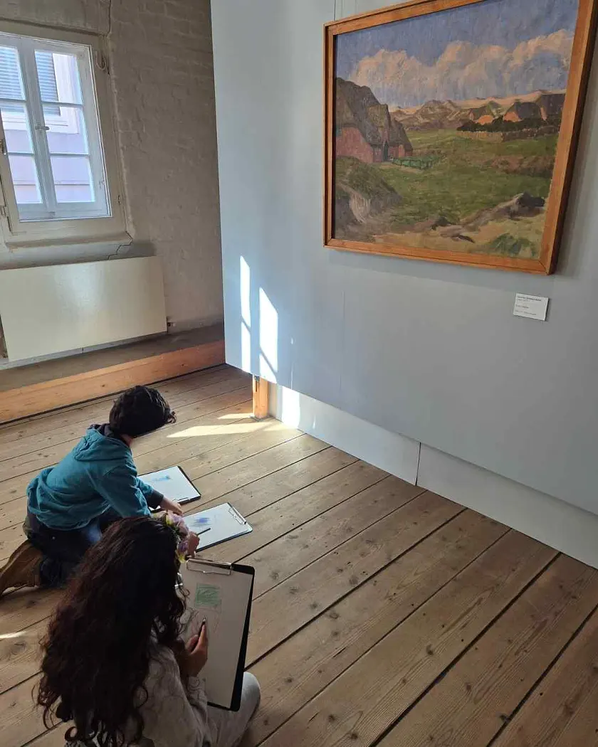 Zwei Kinder sitzen auf dem Fußboden des Overbeck-Museums und zeichnen vor einem Kunstwerk