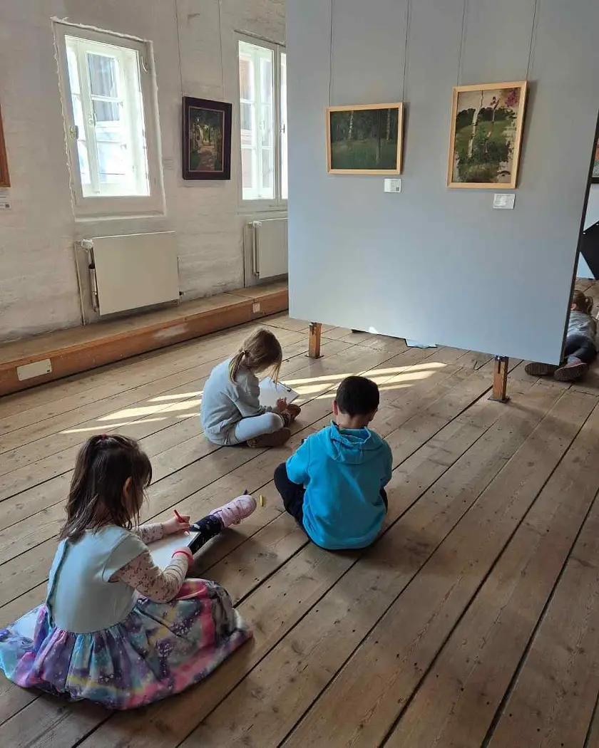 Kinder sitzen vor einem Kunstwerk im Overbeck-Museum und zeichnen