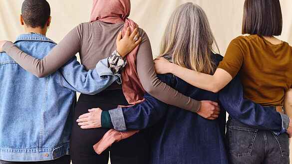 Warnstreik: Foto von Frauen, die im Schulterschluss stehen, von hinten fotografiert