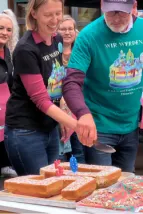 Zentrumsleitung schneidet Kuchen an