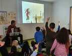 Eine Gruppe Kinder Sitz vor Autor mit Akkordeon in der Hand.