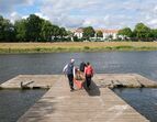 Ruderboot wird auf Steg getragen