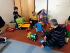 Väter mit Ihren Kindern bauen auf dem Spieleteppich im Kindergarten