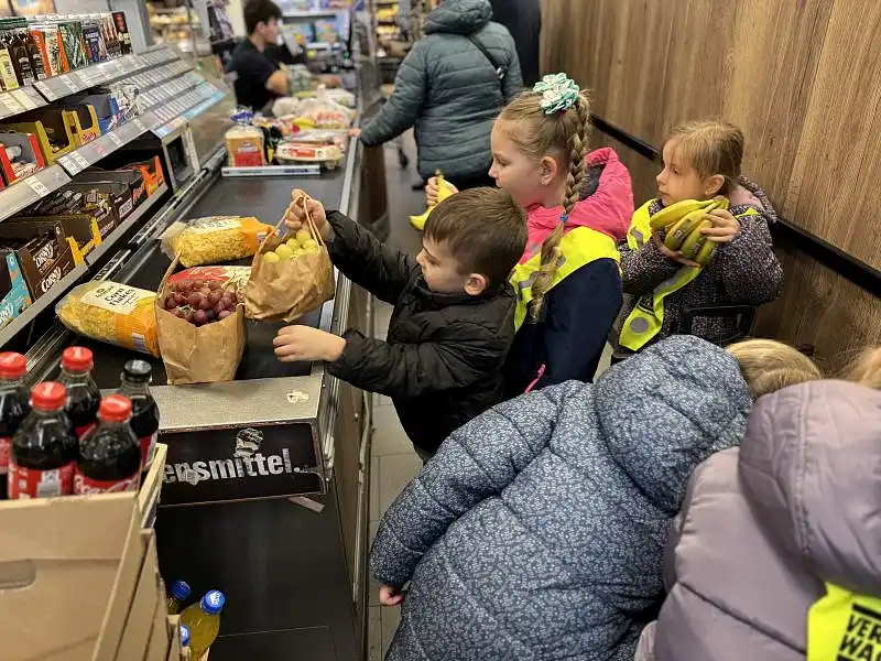 Kinder legen Eink&auml;ufe auf das Kassenband