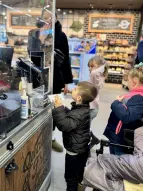 Kleines Kind steht vor Kasse zum Bezahlen.