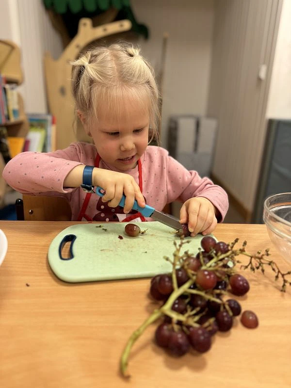 Kind schneidet Obst mit K&uuml;chenmesser