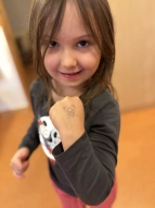 Kind zeigt stolz den Stempel auf dem Handrücken