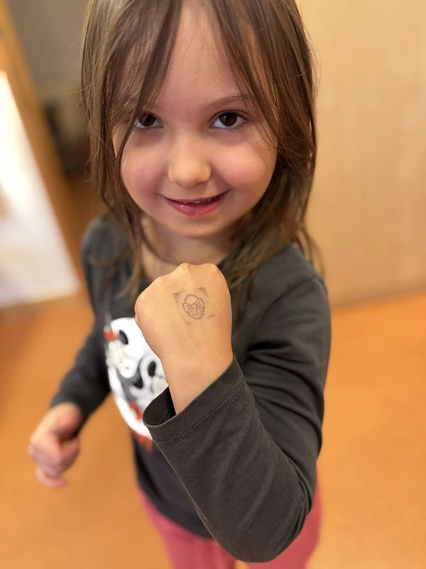 Kind zeigt stolz den Stempel auf dem Handr&uuml;cken