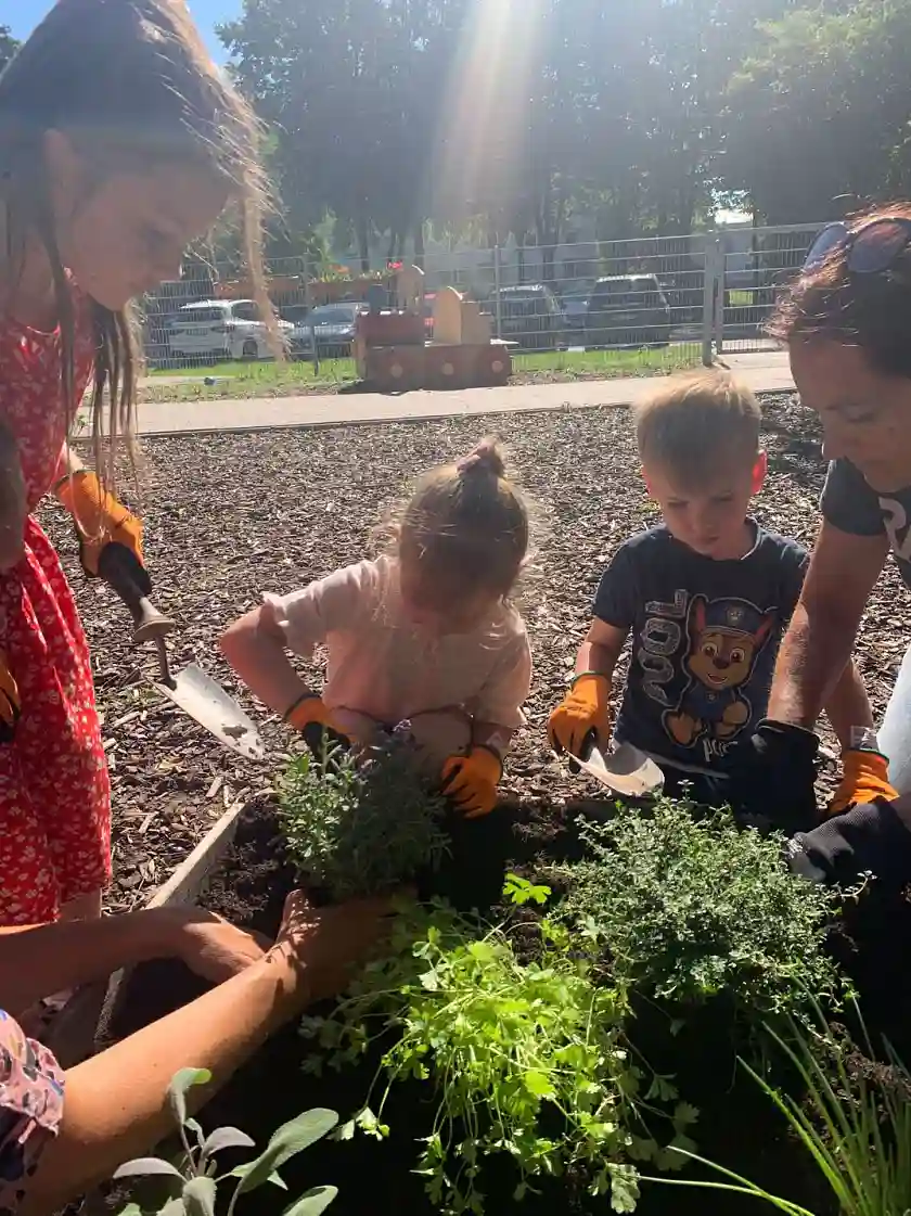 Kinder bepflanzen gemeinsam ein Hochbeet