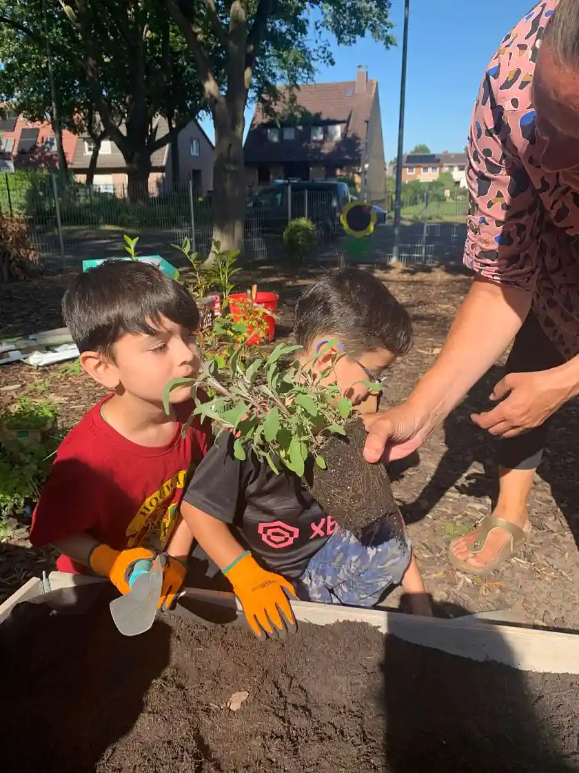 Kind riecht an frischen Kr&auml;utern