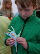 Ein Kind prüft seine gebastelte Papphand