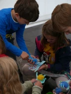 mehrere Kinder vergleichen die von ihnen gebastelten Papphände