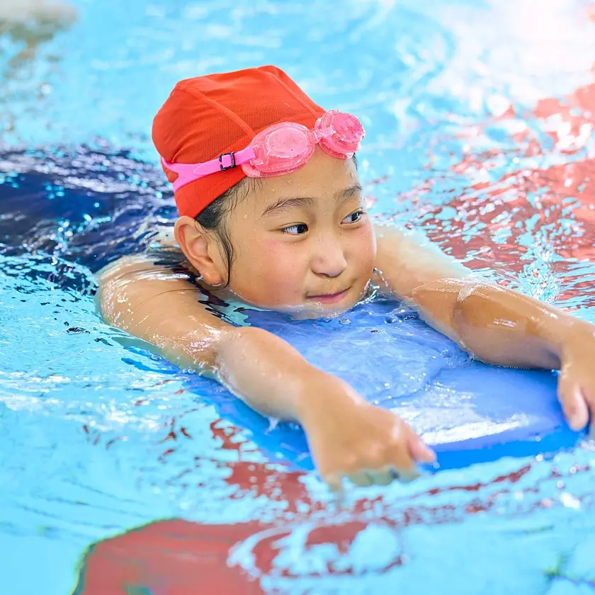 Kind mit Schwimmhilfe im Pool