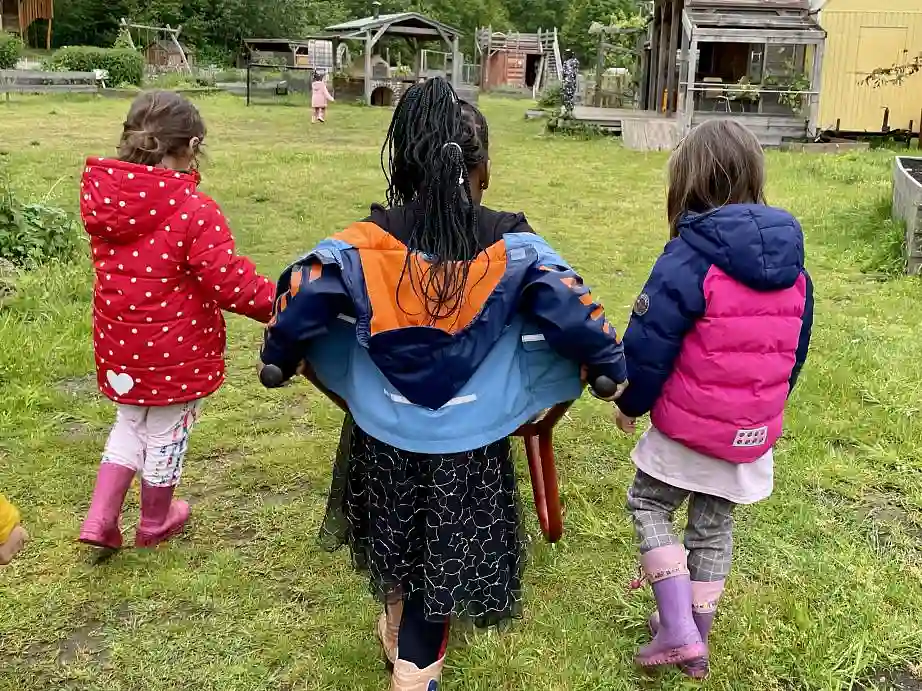 Drei Kinder mit Schubkarre