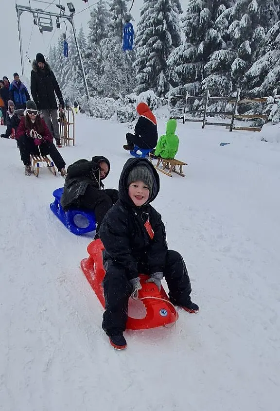 Kind auf Schlitten im Schnee