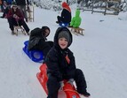 Kind auf Schlitten im Schnee