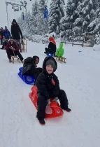 Kind auf Schlitten im Schnee