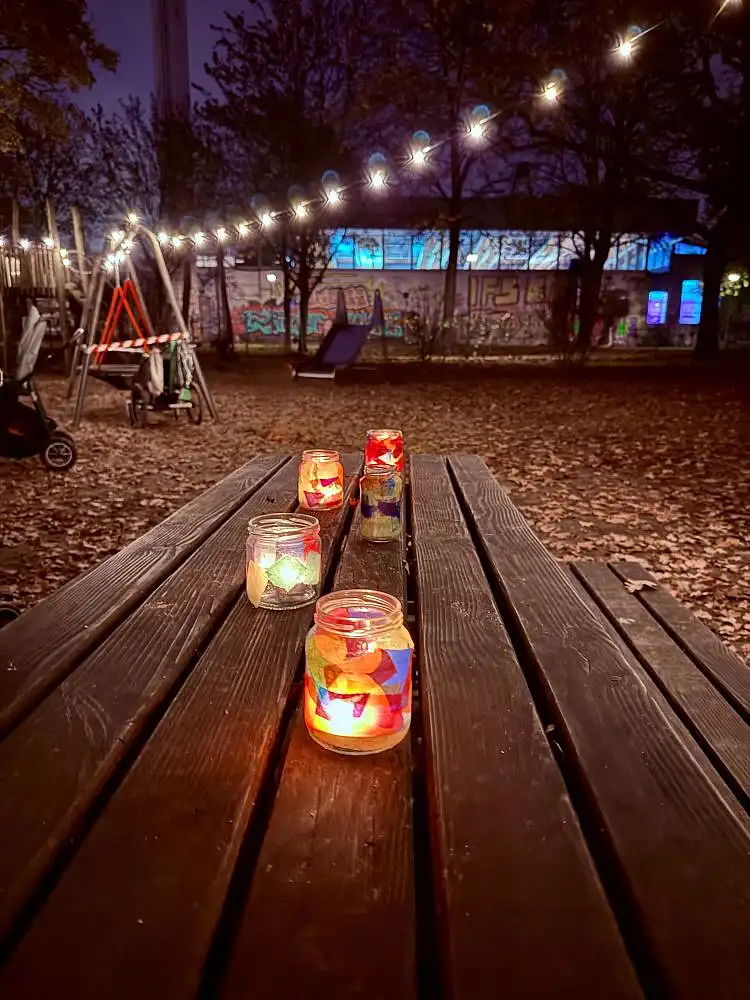 Lichterfest 2024: Bunt beklebte Gl&auml;ser mit Teelichtern leuchten im Au&szlig;enbereich