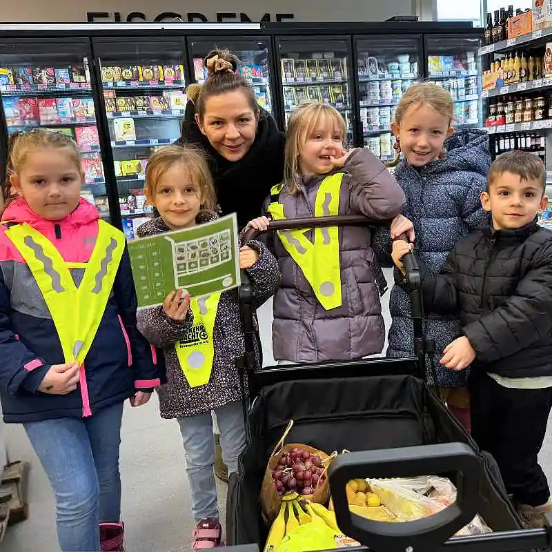 Gruppenfoto von Kindern und Erzieherin im Supermarkt