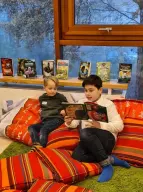 Sechstklässler ließt einem Kindergartenkind vor