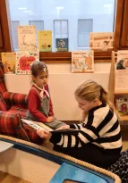 Sechstklässlerin ließt Kindergartenkindern vor