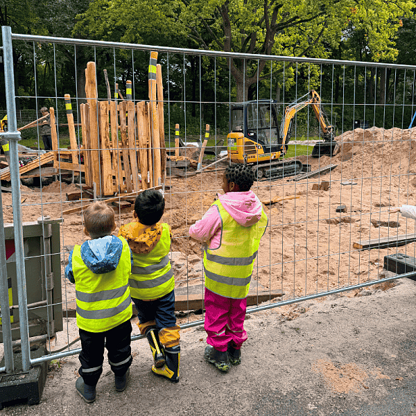 Kinder warten am Bauzaun auf die Fertigstellung des Spielplatzes