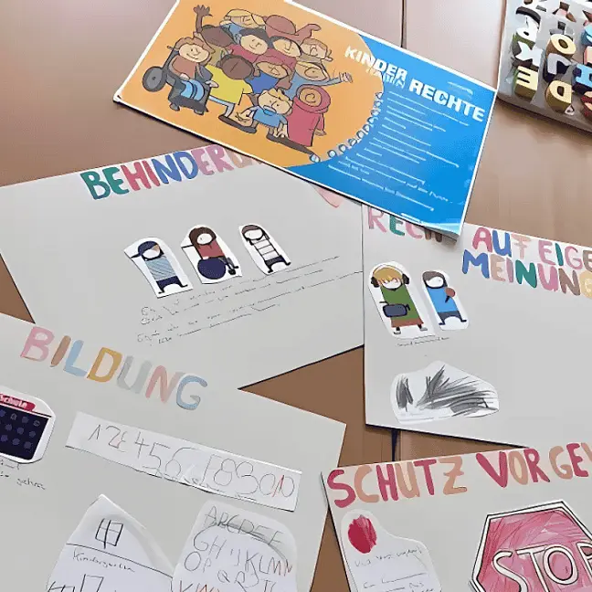 Tisch mit verschiedenen Kunstwerken zu Kinderrechten: Recht auf Bildung, Recht auf Schutz, Recht auf Mitsprache.